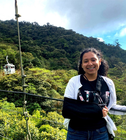 Student posing in front of rainforest 