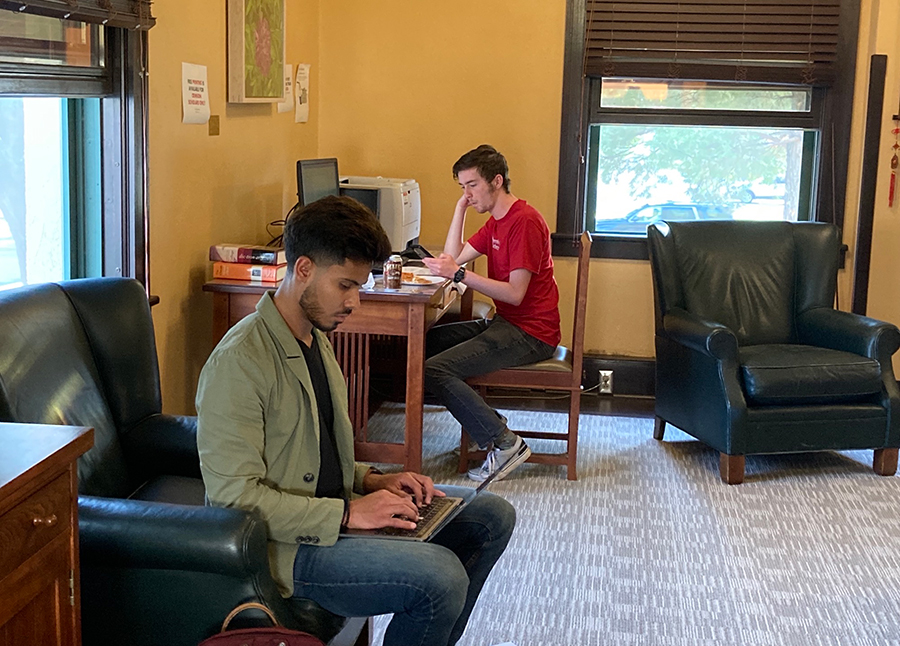  Two men seated in an office working on computers